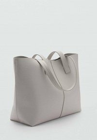Light gray tote bag made of smooth material, featuring two sturdy handles and a minimalist design with rounded edges and no visible hardware.
