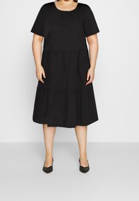Schwarzes kurzärmeliges Kleid mit rundem Ausschnitt und gestaffeltem Saum. Hergestellt aus glattem Stoff, mit lockerer Passform und knielangem Design.