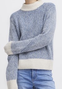 Sweter dzianinowy w kolorze niebieskim i kremowym, z pionowymi paskami, wysokim ribbowym kołnierzem i długimi rękawami. Miękka tekstura i luźny krój.