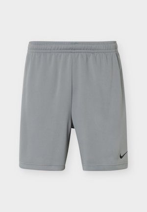 Ανοιχτό γκρι αθλητική βερμούδα με ελαστική μέση και μαύρο λογότυπο Nike στο κάτω δεξί πόδι, παρουσιασμένη σε μονόχρωμο φόντο.