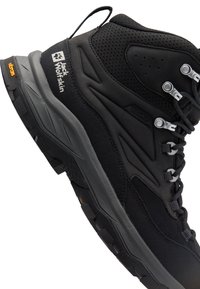 Schwarzer Wanderschuh mit einer Textil-Oberfläche, Gummisohle, grauen Akzenten und Metallösen für die Schnürsenkel, mit einem Logo an der Seite.