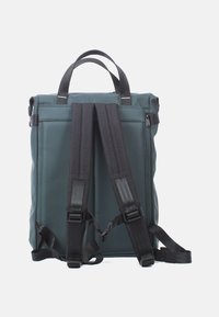 Rugzak met een teal waterdichte buitenkant, zwarte verstelbare straps, een handvat aan de bovenkant en een ritszak aan de zijkant. Plat ontwerp.