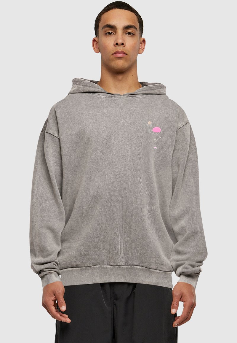 Grå hættebluse med en afslappet pasform, snor i huen og et lille pink flamingo grafik på brystet. Blødt, tekstureret stof.