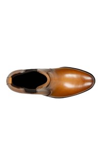 Stivale alla caviglia in pelle marrone con finitura liscia, pannelli laterali elastici, punta tonda e suola piatta in gomma. Nessun hardware o motivo visibile.