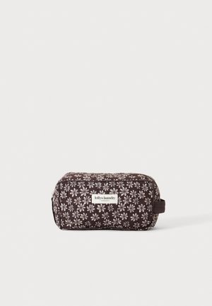 Petite trousse de toilette rectangulaire marron foncé avec motif floral blanc et une anse en tissu sur le côté, étiquetée "lollys laundry."