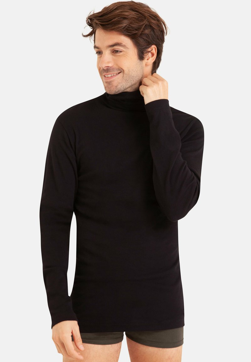 Pull large noir à col roulé en tissu lisse, avec des manches longues et une coupe ajustée, présenté sur un mannequin contre un fond neutre.