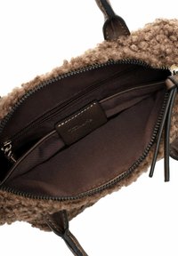 Bolso marrón con una capa exterior texturizada, cierre con cremallera y un interior de tela suave con un bolsillo adicional.