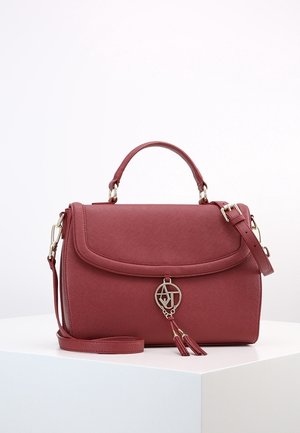 Rote Lederhandtasche mit Tragegriff oben, verstellbarem Schulterriemen, Klappverschluss und einem Metall-Logo-Anhänger mit Quasten auf der Vorderseite.