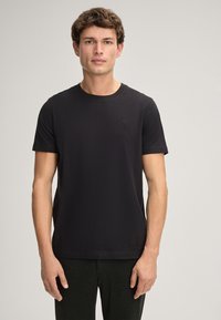 Zwart T-shirt met korte mouwen van zacht, lichtgewicht materiaal. Heeft een ronde hals en een subtiel geborduurd logo op de linkerborst.