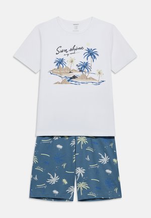 Wit kortärmelig shirt met een palmboom-eilandgrafiek en de tekst "Sun shine on my mind", gecombineerd met blauwe shorts met patronen van palmbomen en zeilboten.