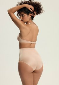 Naga bielizna wysoka w talii o gładkiej teksturze i minimalnych szwach, z regulowanymi ramiączkami i zapięciem na haftek.