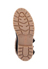 Botte noire avec une semelle en caoutchouc présentant une texture aux motifs antidérapants et une doublure en fausse fourrure beige. Accentuée d'un détail de nœud décoratif.