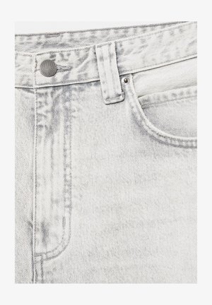 Gros plan sur un jean en denim gris clair montrant un bouton, une boucle de ceinture, une poche avant, un rivet et des coutures détaillées.