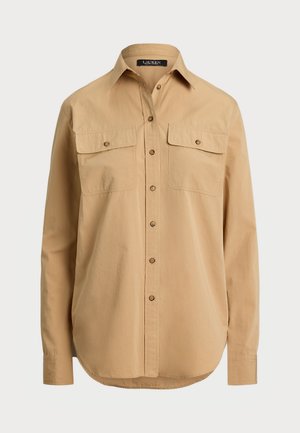 Beige button-up shirt featuring a classic collar, two chest pockets, and a rounded hem. Made of lightweight fabric with a smooth texture.