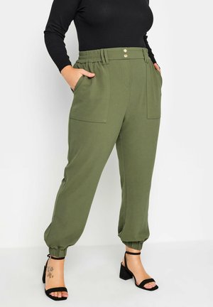 Olivgrüne tapered Jogginghosen mit elastischem Bund und zwei Fronttaschen. Besondere Merkmale sind Knopfdetails und gerippte Bündchen an den Knöcheln.