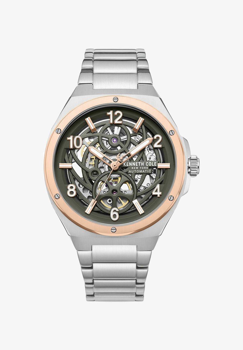Zegarek ze stali nierdzewnej w kolorze srebrnym z zieloną szkieletem tarczą, różowozłotymi akcentami, dużymi cyframi oraz szczotkowanym metalowym paskiem.