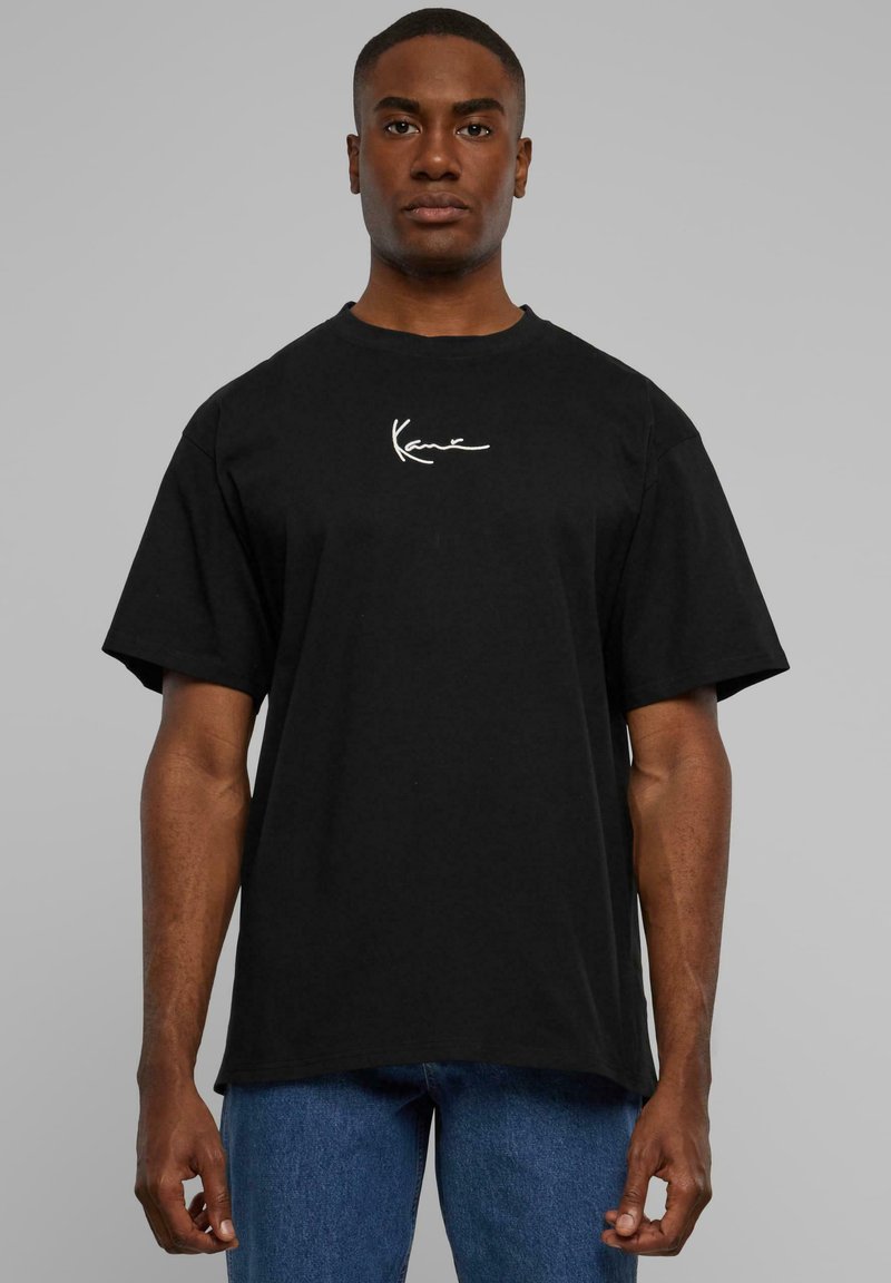 Black cotton t-shirt featuring a white signature logo on the left chest, with a crew neck and short sleeves. Classic straight fit.