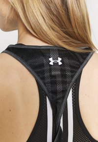 Schwarzes Sport-Top mit Mesh-Textur, Racerback-Design, grauen Akzenten und einem weißen Logo auf dem oberen Rücken.