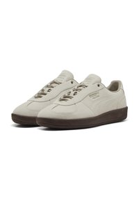 Sneakers din suede de culoare bej deschis, cu o talpă din cauciuc texturat de culoare maronie. Dispun de șireturi plate, vârf rotunjit și accente cu logo embossat.