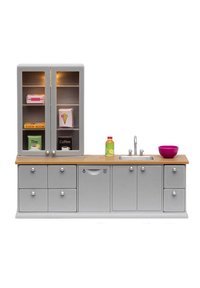Unità cucina grigia con piano di lavoro in legno, accessori in metallo argento, due armadi, quattro cassetti, lavello e ciotola rosa. Include vari oggetti decorativi.