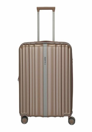 Mittelgroßer Hartschalenkoffer in Bronze mit vertikalen Rillen, vier Doppelrollen, Teleskopgriff und mittlerem silbernem Streifen mit Markennamen.