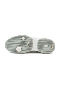Suela de zapatilla deportiva blanca con un patrón de banda de rodadura en zigzag, que cuenta con dos inserciones circulares de agarre y marca. Material suave y duradero.