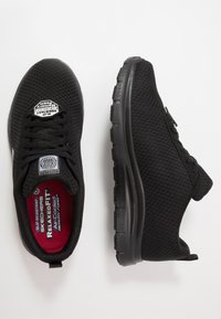 Black athletic shoes with a mesh upper, slip-resistant sole, lace-up design, and a lightly padded insole featuring a red accent.