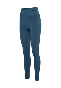 Blauwe naadloze leggings met hoge taille, subtiele geribbelde zijpanelen en klein zwart "hummel" logo op de tailleband tegen een witte achtergrond.