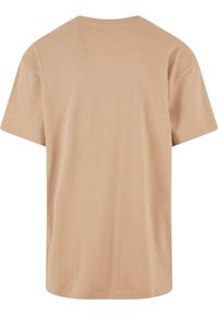 Beige katoenen t-shirt, korte mouwen, ronde hals, relaxte pasvorm. Gladde textuur zonder grafische afbeeldingen of versieringen op de achterkant.