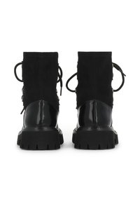 Botines negros con base de charol y parte superior de ante. Presentan cordones, detalles metálicos y una suela gruesa y texturizada.