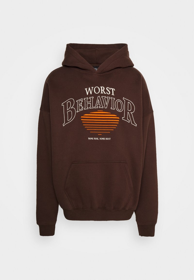 Sweat à capuche marron avec poche avant, avec le texte « Worst Behavior » et un motif de coucher de soleil rayé orange.