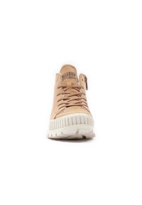 Beige suède sneaker met veters en een zijrits, met een gestructureerde witte rubberen zool met horizontale ribbels. Merkreferentie zichtbaar op de tong.