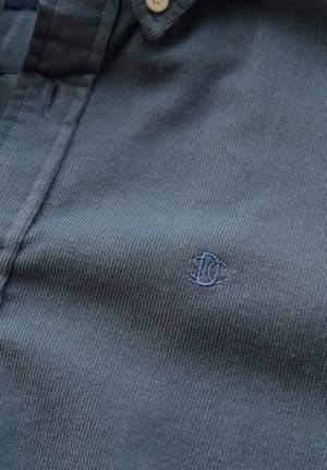 Dark gray corduroy shirt featuring a buttoned collar, vertical ribbed texture, and a small blue embroidered logo on the chest.