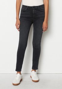 Tummat farkut kapeat, korkealla vyötäröllä, jossa on viisi taskua ja hienovaraiset kulutukset. Tyylitelty valkoisilla tennareilla kontrastiksi.