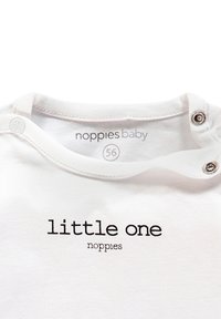 Weißer Baby-Overall mit rundem Halsausschnitt und Druckknopfverschlüssen, bedruckt mit "little one" in schwarzem Text und einem Etikett mit der Aufschrift "noppies baby."