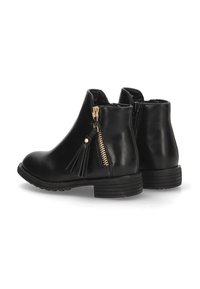 Botas de tobillo de cuero negro con un bajo tacón cuadrado, con cremalleras laterales y un adorno de borlas decorativas. Textura suave, diseño simple.