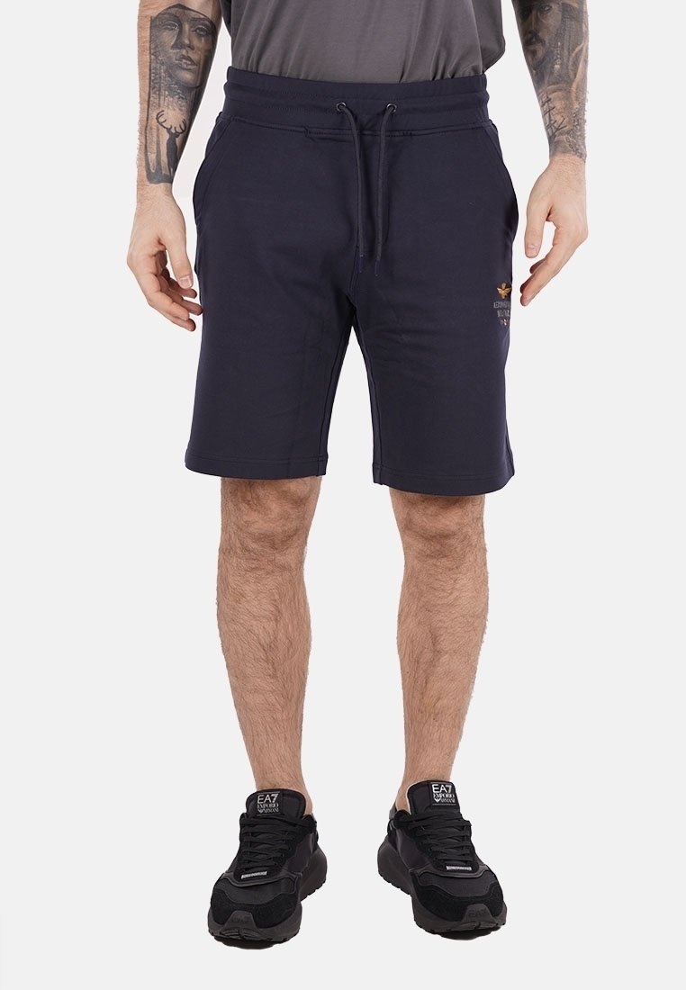 Pantaloni corti in cotone blu navy con vita elastica e cordino. Presentano tasche laterali e un piccolo dettaglio del logo ricamato.