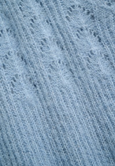 Tissu tricoté doux et duveteux bleu clair avec une texture côtelée verticale et des fibres fines de fil visibles.
