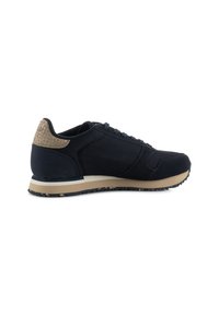 Navy sneaker with mesh upper and suede accents, featuring a textured tan heel, beige midsole, and black rubber outsole.