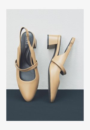 Kohvatooni nahast slingback kingad madala ruudukujulise kontsaga, millel on ümar varvas ja dekoratiivne rihm üle jala.