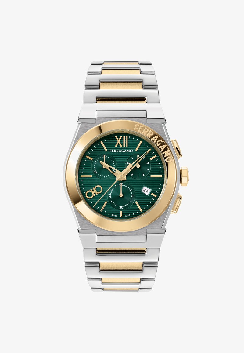 Sudraba un zelta toņu nerūsējošā tērauda pulkstenis ar zaļu teksturētu ciparnīcu, zelta akcentiem, hronogrāfa subciparnīcām un datuma rādītāju pie sešiem.