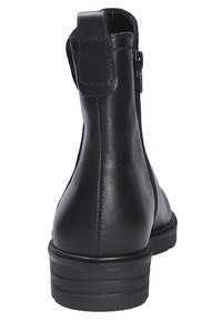 Bottine en cuir noir avec une texture lisse, un petit talon empilé, et une fermeture éclair sur le côté, avec une languette à l'arrière.