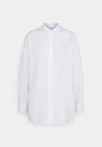 Chemise blanche à manches longues avec col mao, dotée d'une patte de boutonnage à l'avant et d'une texture en coton lisse. Pas de motifs ni d'accents visibles.