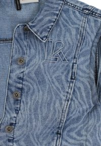 Lichtblauw denim vest met een golvend patroon, voorzien van zilveren drukknopen en een gestikte "Lk"-logodetail op de linkerborst.
