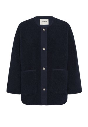 Veste polaire bleu marine à boutons, avec col rond et deux poches plaquées à l'avant, étiquette "soaked" à l'intérieur du col.