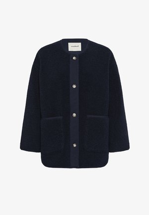 Giacca in pile blu navy con bottoni, collo rotondo e due tasche applicate frontali, con etichetta "soaked" all'interno del colletto.