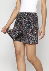 Shorts neri a fantasia floreale con vita elastica e cordino, caratterizzati da accenti rossi, gialli e verdi, realizzati in tessuto leggero.