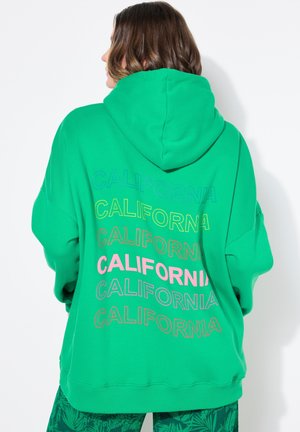 Green hoodie made of soft fabric, featuring a large hood and multicolored "CALIFORNIA" text printed on the back in varying sizes.