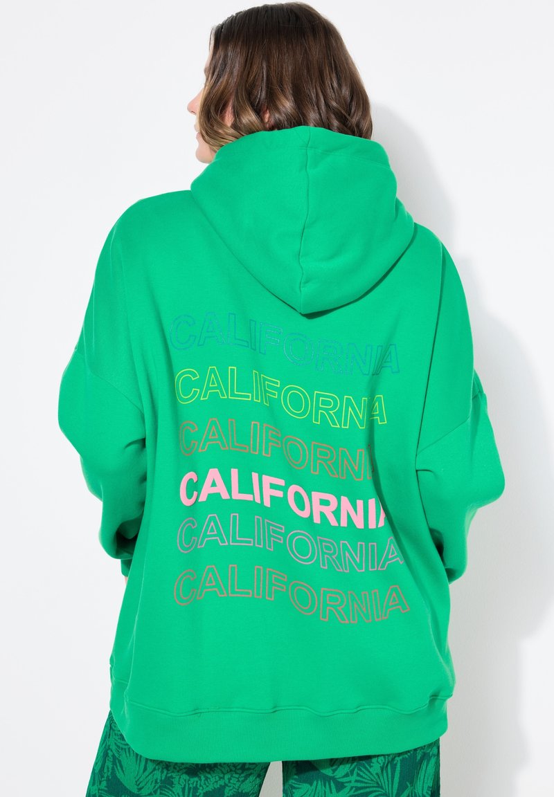 Vihreä huppari pehmeästä kankaasta, jossa on suuri huppu ja monivärinen "CALIFORNIA" -teksti painettuna selässä eri kokoisina.