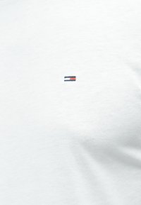 Λευκό βαμβακερό T-shirt με μικρό κεντημένο λογότυπο που παρουσιάζει οριζόντιες ρίγες σε κόκκινο, άσπρο και μπλε στην αριστερή πλευρά του στήθους.